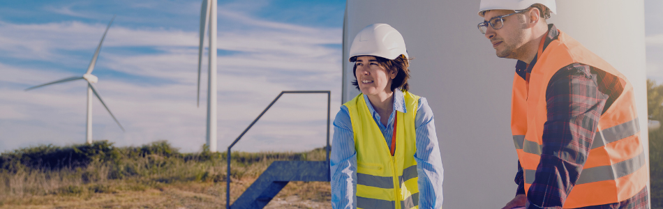 Construction workers onsite with windmills in the background.