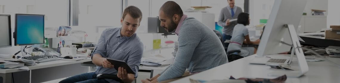 Man showing colleague work information on tablet