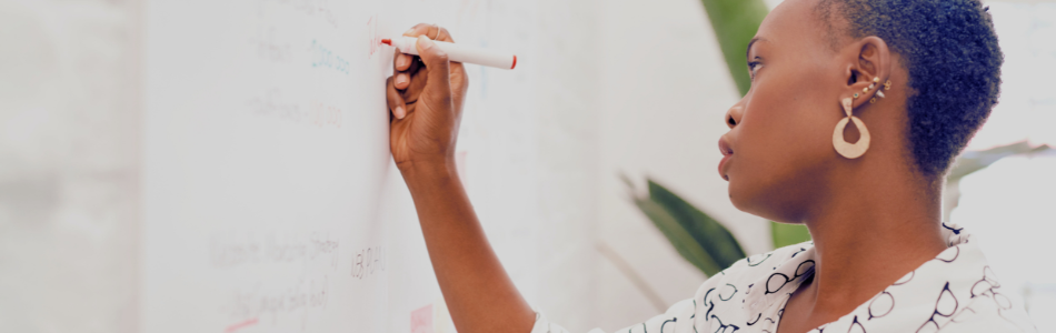 lady writing something on a white board in a professional setting