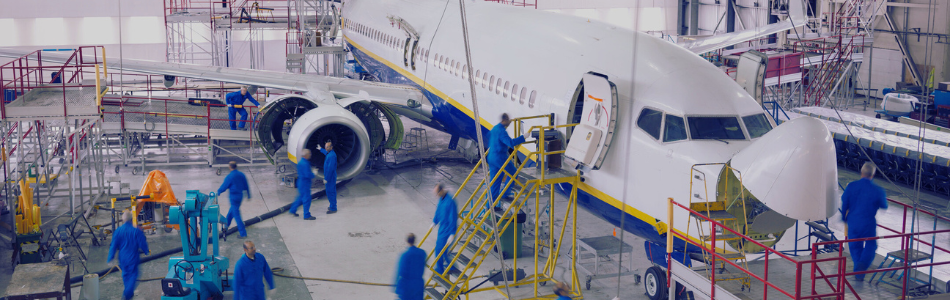 Plane hangar with workers working on an aeroplane construction